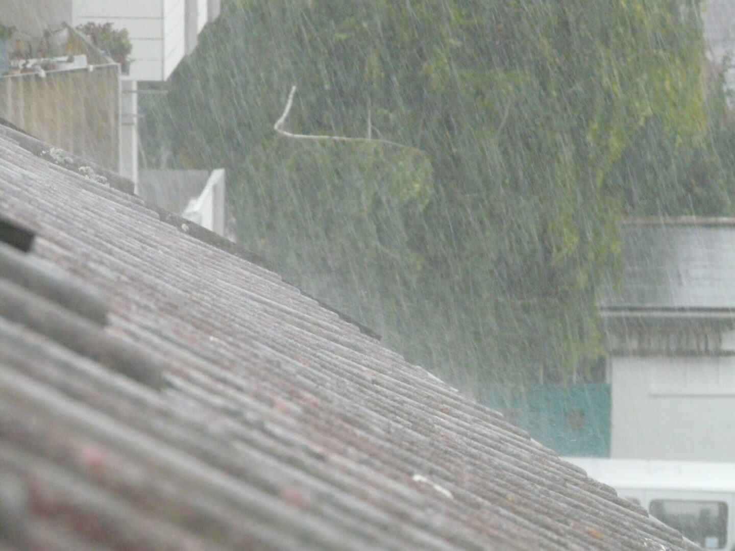 A rain storm is pouring down on the roof of a house.