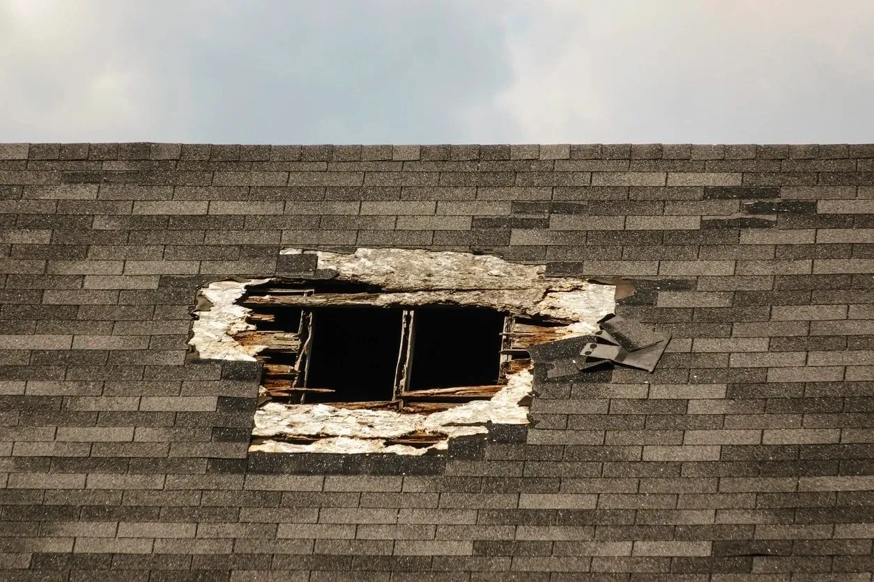 A hole in the roof of a house that has been torn down.