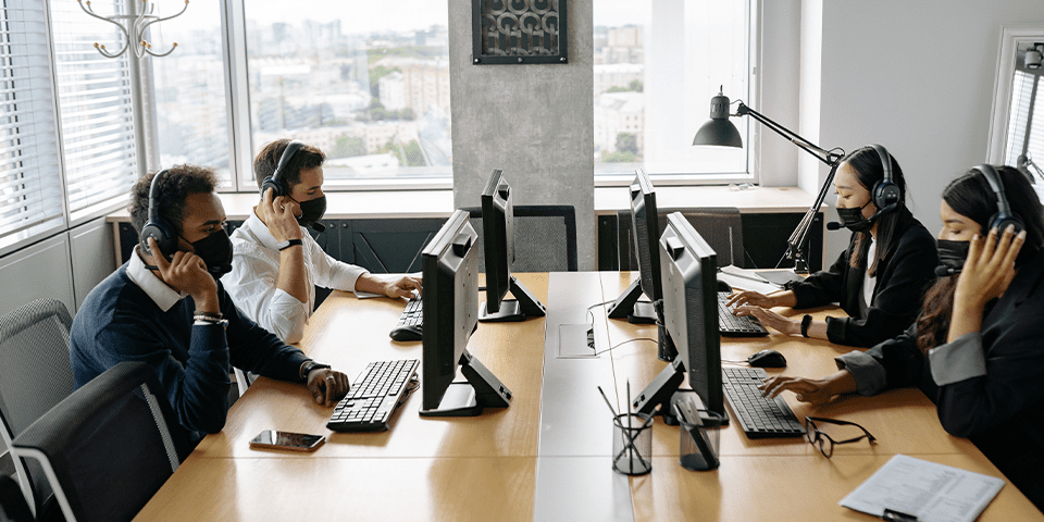 A group of people sitting at tables with computers.