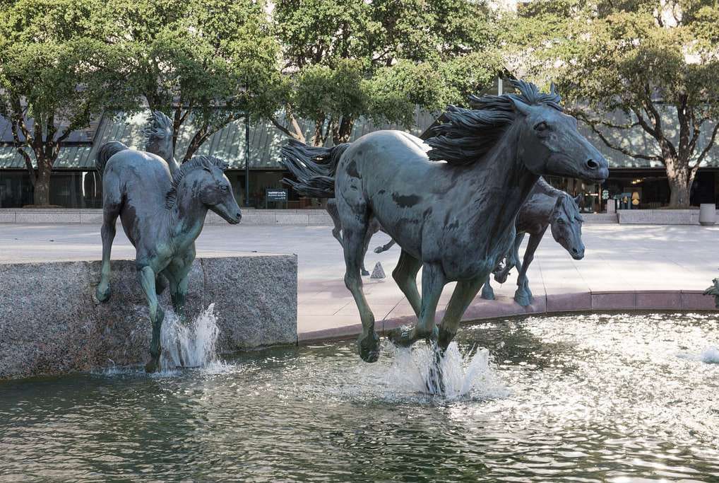 Mustangs of Las Colinas Statues running through water, part of the community we serve with public adjusters.